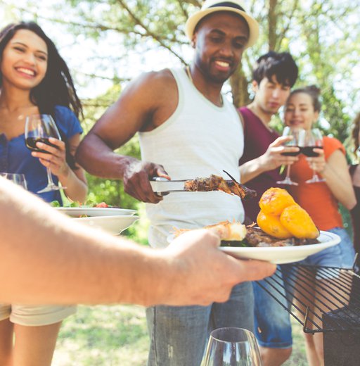 Group of friends making barbecue in the nature.